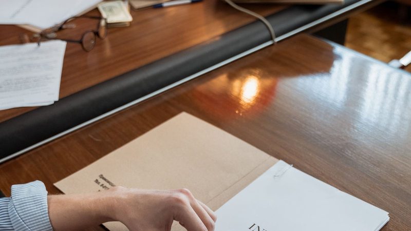 Hands sorting through supplier invoices on an office desk