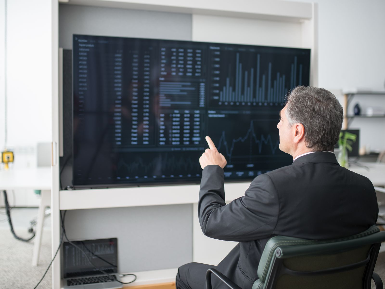Analyst reviewing spend data on a large screen